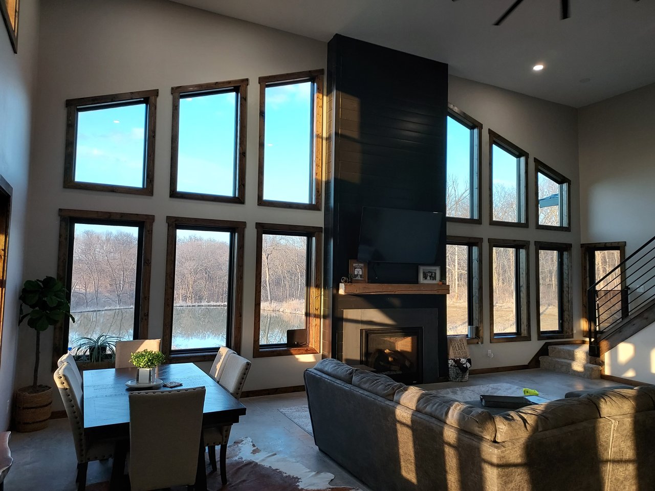 Living room with tall windows, a dark fireplace, and views of the landscape
